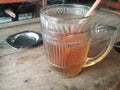 A large glass of iced tea with an ashtray on a wooden table. Aesthetic and traditional. Anchient, vintage