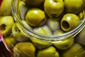 Large glass jar of green pitted olives closeup detail Royalty Free Stock Photo