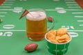 Large glass mug of cold beer on table with superbowl party decor