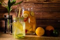 Large glass pitcher with citrus flavored water and homemade lemonade. Glass or jar with drink, lid and straw. Freshness, health