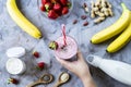 A large glass of strawberry-banana smoothie with ingredients Royalty Free Stock Photo