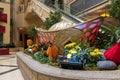Large gold coins surrounded by lush green plants and colorful flowers in the waterfall atrium at The Venetian Resort and Hotel