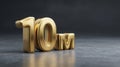 Large Polished Gold 10M Milestone Displayed in Dark Charcoal Grey Studio With Soft Bokeh for Advertising Purposes Royalty Free Stock Photo