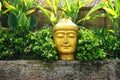 Large golden Buddha head atop a stone wall in Bali Royalty Free Stock Photo