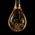Large golden liquid drop with internal bubbles against black background yellow Royalty Free Stock Photo