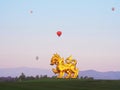 Large golden Singha Lion statue over sunrise sky background with colorful balloons at Singha Park Boon Rawd Farm, Chiang Rai Royalty Free Stock Photo