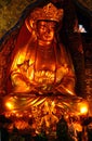 Large golden statue of Avalokitesvara Bodhisattva Guan Yin in Puji Temple Hangzhou and small figure of a monk at its foot