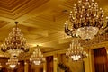 Large Golden vintage crystal chandeliers on the ceiling in the rich hall