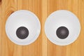 Large googly eyes on a wood desk