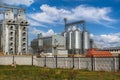 large grain elevator with multiple cylindrical metal silos, structural elements, and a complex system of pipes. It stands against Royalty Free Stock Photo