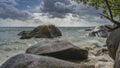 Large granite boulders in the water and on the shore of the turquoise ocean Royalty Free Stock Photo