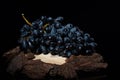 large grapes on a wooden stand on a black background