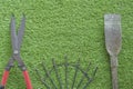 Large grass cutting shears, red handle, steel rake, digging shovel, lawn background Royalty Free Stock Photo