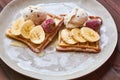 Large gray ceramic plate with fresh Belgian sweet waffles, ice cream, strawberries, bananas and condensed milk. Delicious breakfas Royalty Free Stock Photo