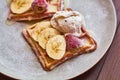 Large gray ceramic plate with fresh Belgian sweet waffles, ice cream, strawberries, bananas and condensed milk. Delicious breakfas Royalty Free Stock Photo