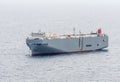 Large gray roll-on/roll-off RORO or ro-ro ships or oceangoing vehicle carrier ship anchor in the open sea.