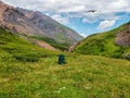 Large green backpack on the grass of an Alpine slope. Hiking in the highlands. Amazing bright mountain landscape of majestic Royalty Free Stock Photo