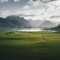 large green field with a lake and mountains in the background Royalty Free Stock Photo