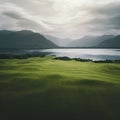 large green field with a lake and mountains in the background Royalty Free Stock Photo