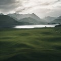 a large green field with a lake and mountains in the background Royalty Free Stock Photo