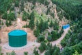 Large Green Industrial Water Chemical Storage Tank in Forest of Mountain Hills Royalty Free Stock Photo