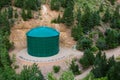 Large Green Industrial Water Chemical Storage Tank in Forest of Mountain Hills