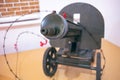 A large green machine gun on a pedestal with a muzzle aimed at us