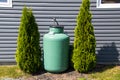 A large green propane tank on the side of a house Royalty Free Stock Photo