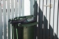 a large trash can near a gray fence. background for the design. garbage collection Royalty Free Stock Photo