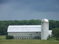 Large grey barn and silo in a field in Vermont Royalty Free Stock Photo