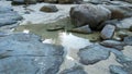 Large grey rocks and boulders in calm shallow sea water, wide image Royalty Free Stock Photo