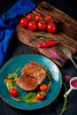 Large grilled beef steak on a plate with cherry tomatoes and mustard in plate