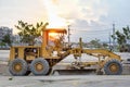 Large ground leveling machine or grader for road or street highway making park at work place with sunset at evening Royalty Free Stock Photo