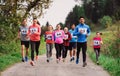 Large group of multi generation people running a race competition in nature.