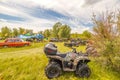 a large group of ATVs stand in the background against the blue sky on a summer sunny day. Russian fans of pokatushek gathered in