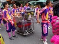 Large group of boys carry a cart with drums in the parade of a Festival of the Clans of the Chinese community of Bangkok