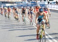 Large group of colorful triathletes cycling