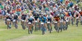 Large group of fighting mountainbike cyclists cycling uphill