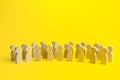 A large group of figurines of people on a yellow background. Social survey and public opinion, electorate. Population and citizens