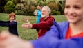 Large group of fit and active people doing exercise in nature, stretching. Royalty Free Stock Photo