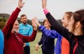 Large group of fit and active people resting after doing exercise in nature.