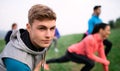 Large group of fit and active people stretching after doing exercise in nature. Royalty Free Stock Photo