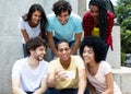 Large group of international young adult people looking at mobil