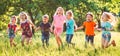 Large group of kids, friends boys and girls running in the park on sunny summer day in casual clothes . Royalty Free Stock Photo