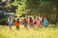 Large group of kids, friends boys and girls running in the park on sunny summer day in casual clothes . Royalty Free Stock Photo