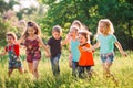 Large group of kids, friends boys and girls running in the park on sunny summer day in casual clothes . Royalty Free Stock Photo