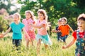 Large group of kids, friends boys and girls running in the park on sunny summer day in casual clothes . Royalty Free Stock Photo