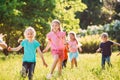 Large group of kids, friends boys and girls running in the park on sunny summer day in casual clothes . Royalty Free Stock Photo