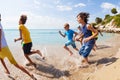 Group of kids running run on beach water edge Royalty Free Stock Photo