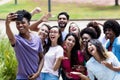 Large group of multi ethnic young adults taking crazy selfie with phone